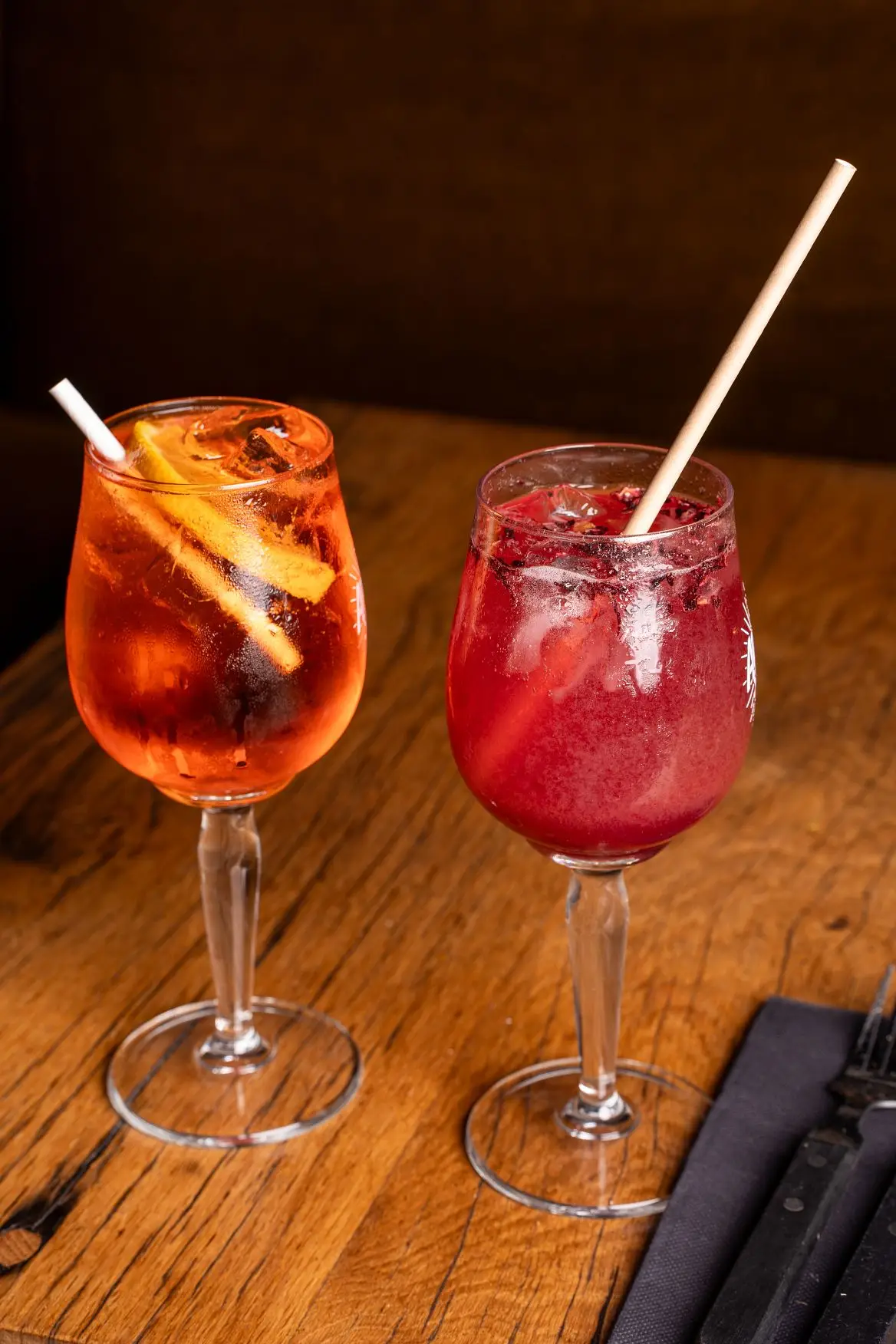 Spritz à l'orange et cocktail aux fruits rouges sur table en bois